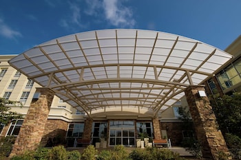 Stunning hotel entrance with an arched glass canopy and stone pillars. at DoubleTree by Hilton North Charleston - Convention Center
