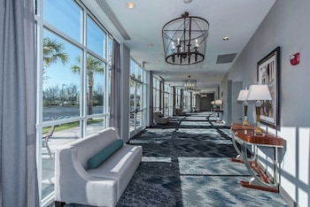 Stroll through our stylish corridor, featuring a patterned carpet, a comfortable sofa, and elegant lighting fixtures. at DoubleTree by Hilton North Charleston - Convention Center