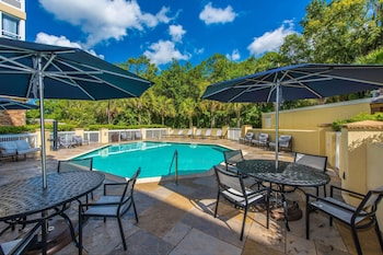 Relax by the pool surrounded by lush greenery and comfortable lounge chairs. at DoubleTree by Hilton North Charleston - Convention Center