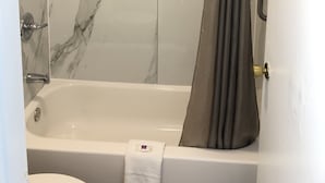 Un baño con cabina de ducha de mármol, bañera y retrete.