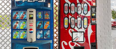 Two vending machines, one for Pepsi and one for Coca-Cola, with various drink options and payment methods.