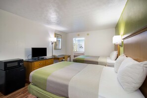 A hotel room with a bed, a desk with a computer, a television, and a refrigerator. - Motel 6 Parkersburg, WV (Parkersburg)