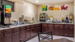 Una cucina d'hotel con un angolo bevande self-service, un'area buffet e una zona salotto.