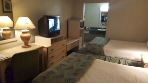 A hotel room with two beds, a desk with a television, and a mirror. - The Brooke Hotel (Brookshire)