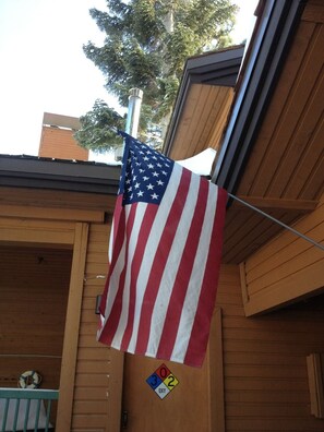 Een Amerikaanse vlag bevestigd aan een gebouw met een houten gevel en een balkon.
