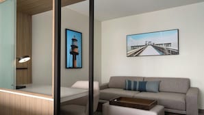 A modern room with a desk, a sofa, and two framed pictures on the wall. - SpringHill Suites by Marriott Fort Myers Airport (Fort Myers)
