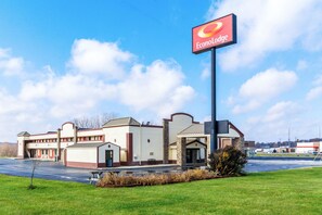 A hotel with a prominent sign, a parking lot, and a grassy area in front. - Econo Lodge Cloverdale (Cloverdale)