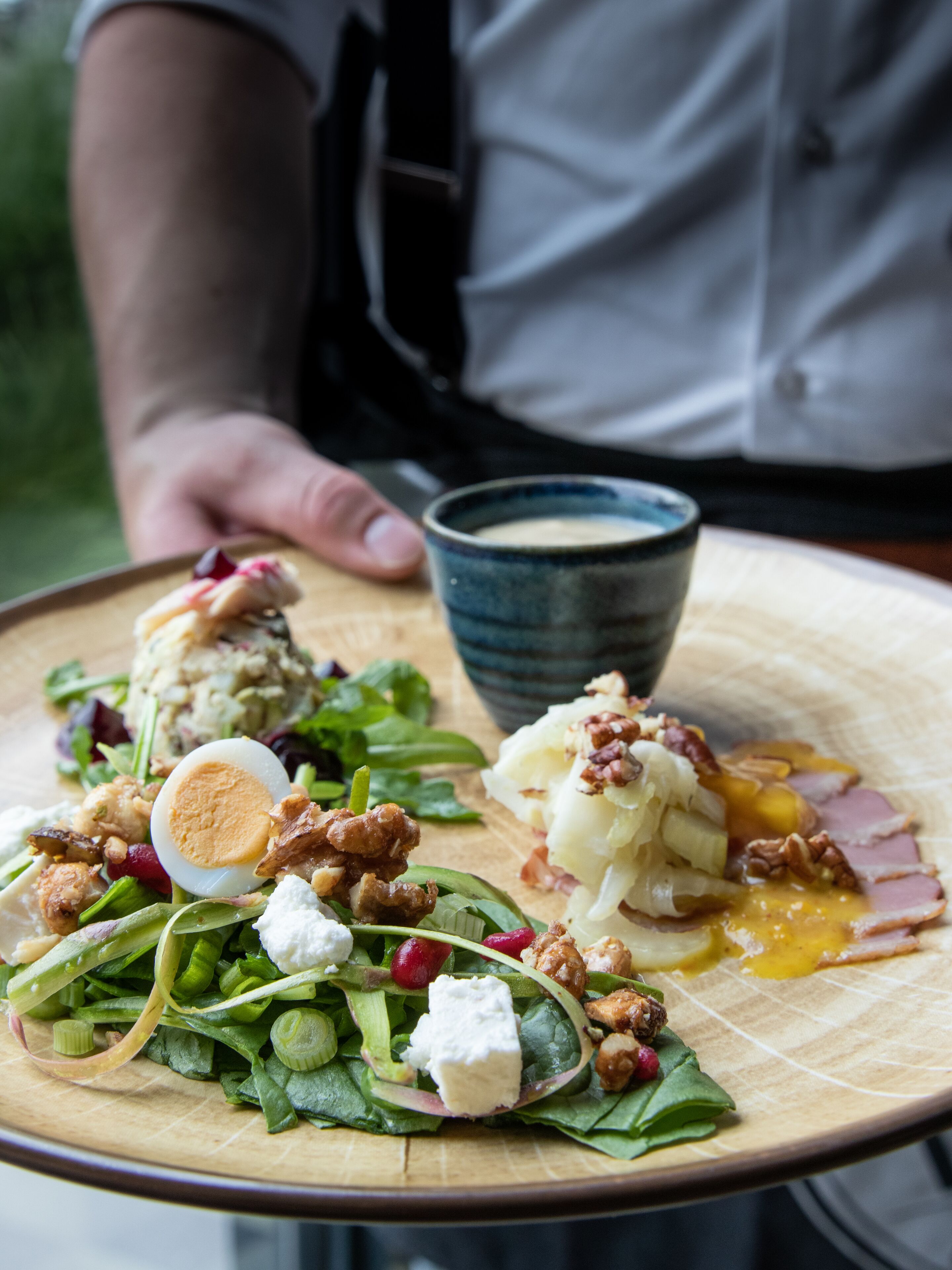 Une assiette de nourriture contenant divers éléments, notamment des légumes verts, des noix et un œuf dur.