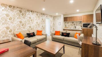 Una sala de estar con dos sofás, una mesa de centro y un televisor.