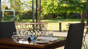 A dining table set with a glass, water glass, and a sign reading "RESERVED". - Croydon Lodge Hotel (Croydon)