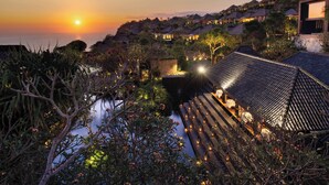 A resort with traditional architecture, a pool area, and a sunset view. - Bvlgari Resort Bali (Pecatu)