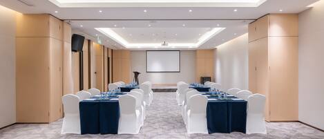A conference room with tables set for meetings, equipped with projectors and screens.