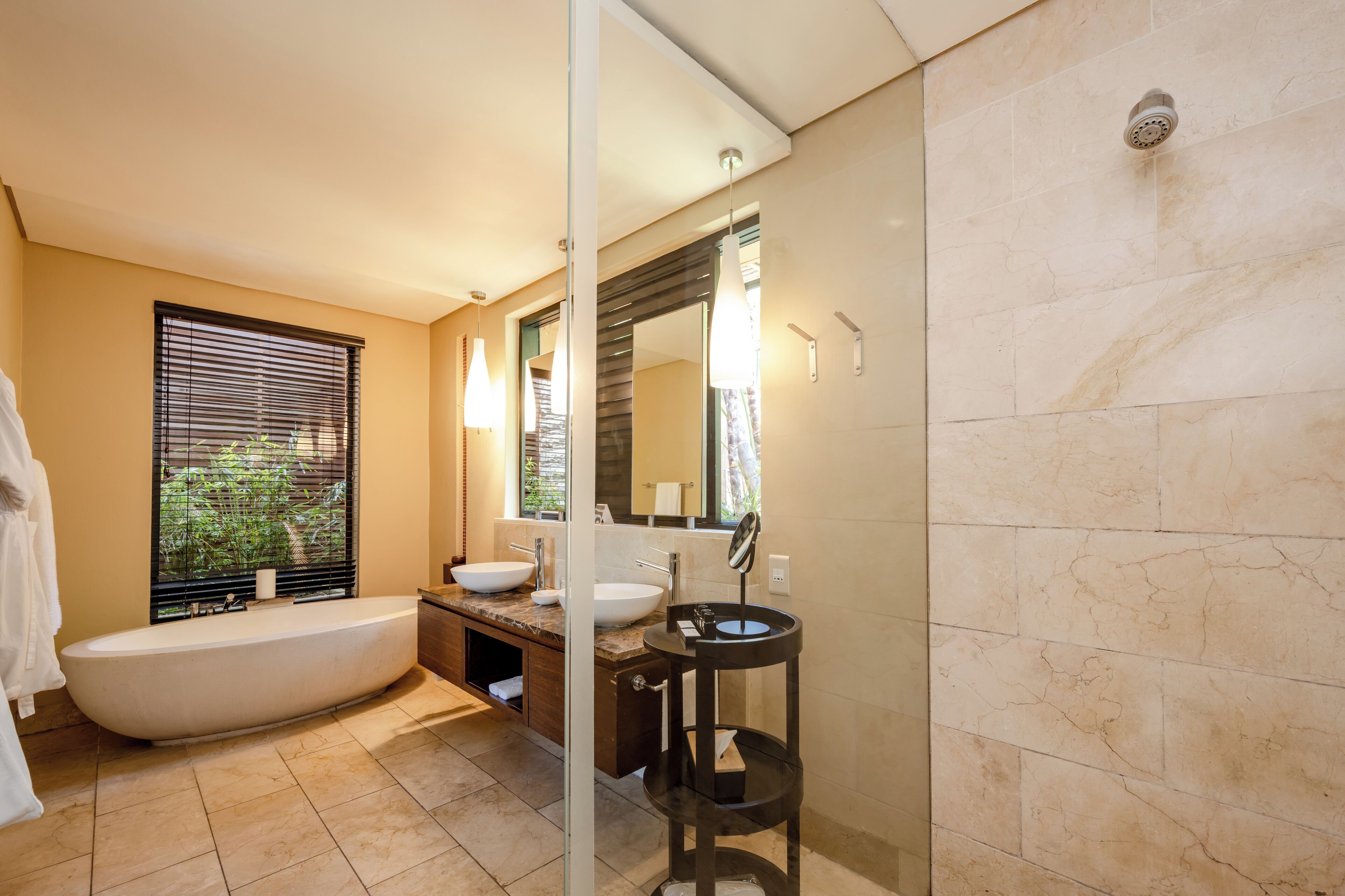 A modern bathroom with a freestanding bathtub, a round sink, and a large mirror.
