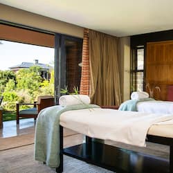Relax in a serene space with two massage tables and a calming view of the outdoors.