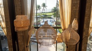 A room with large windows, wicker hanging lamps, and a view of a pool and palm trees. - Pezula Nature Retreat (Knysna)