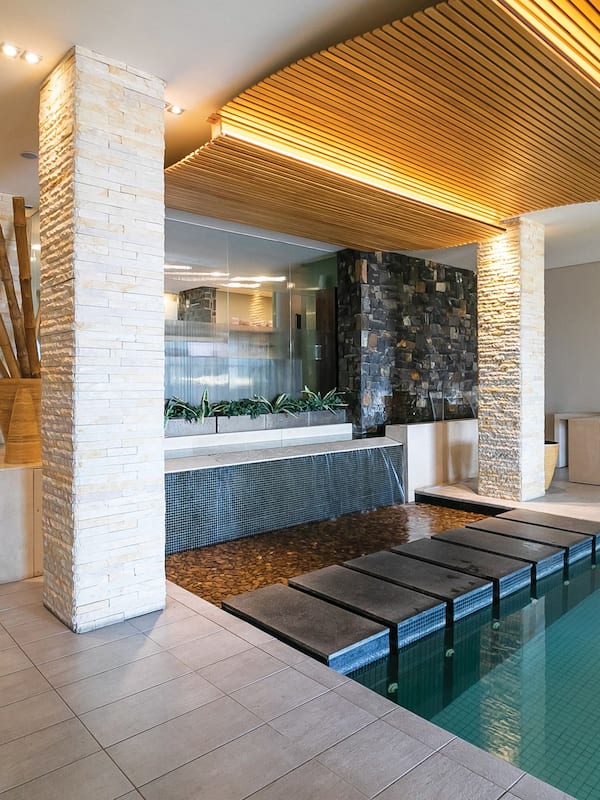 Enjoy a refreshing swim in the pool surrounded by steps leading to a lower level with a seating area.
