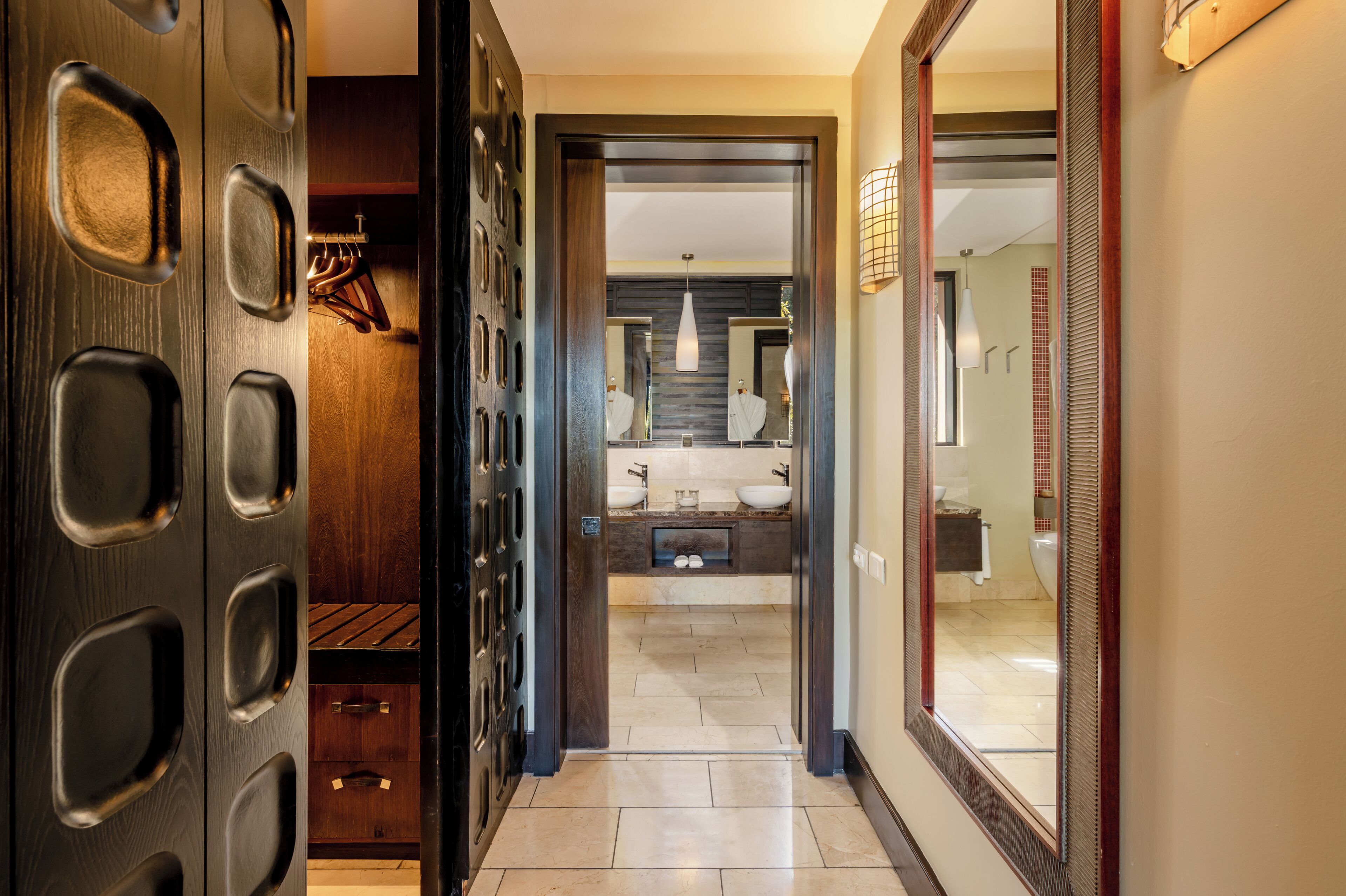 Un baño moderno con un espejo grande, dos lavamanos y una zona de ducha.
