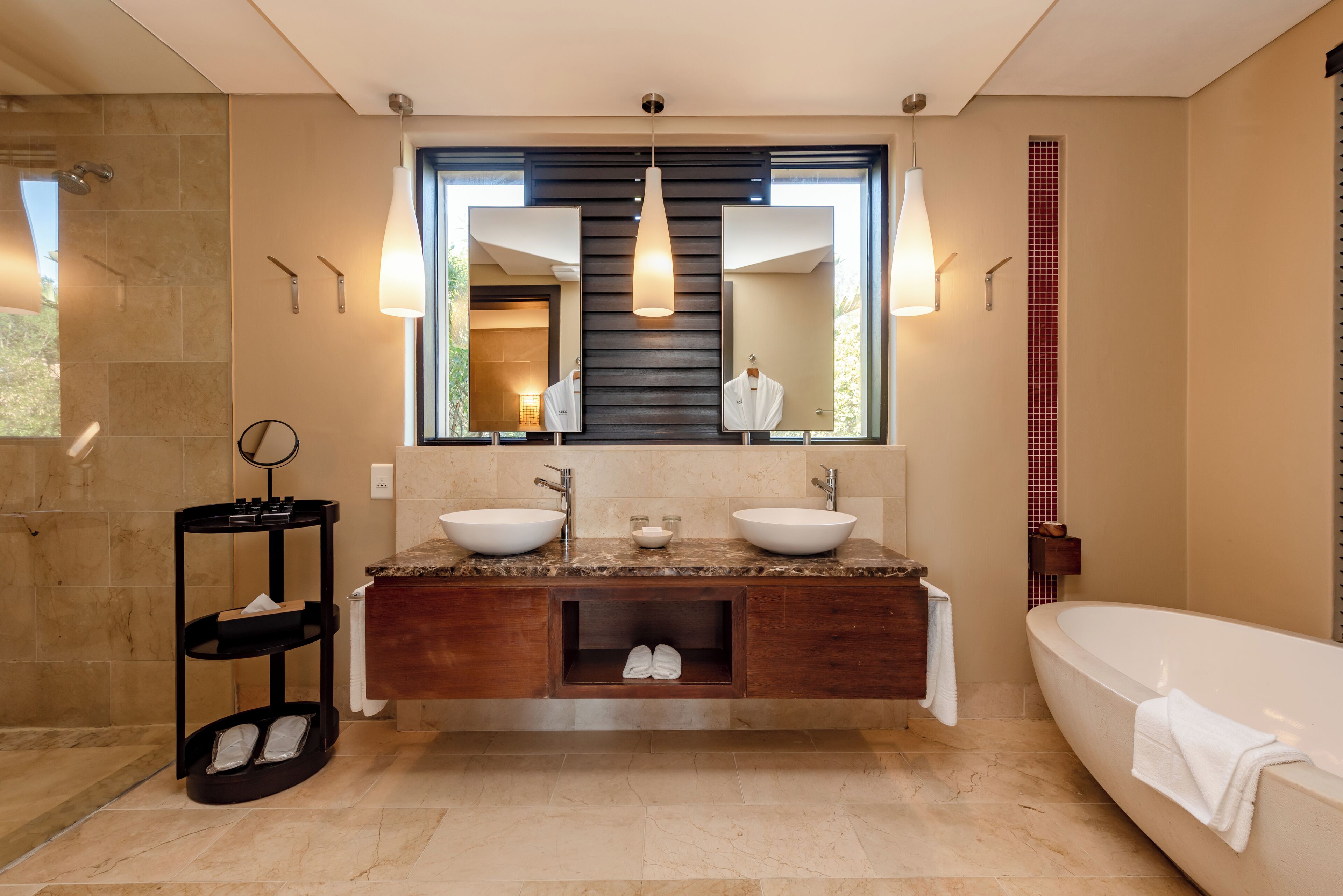 Une salle de bain moderne avec deux lavabos, un grand miroir et un radiateur sur pied.