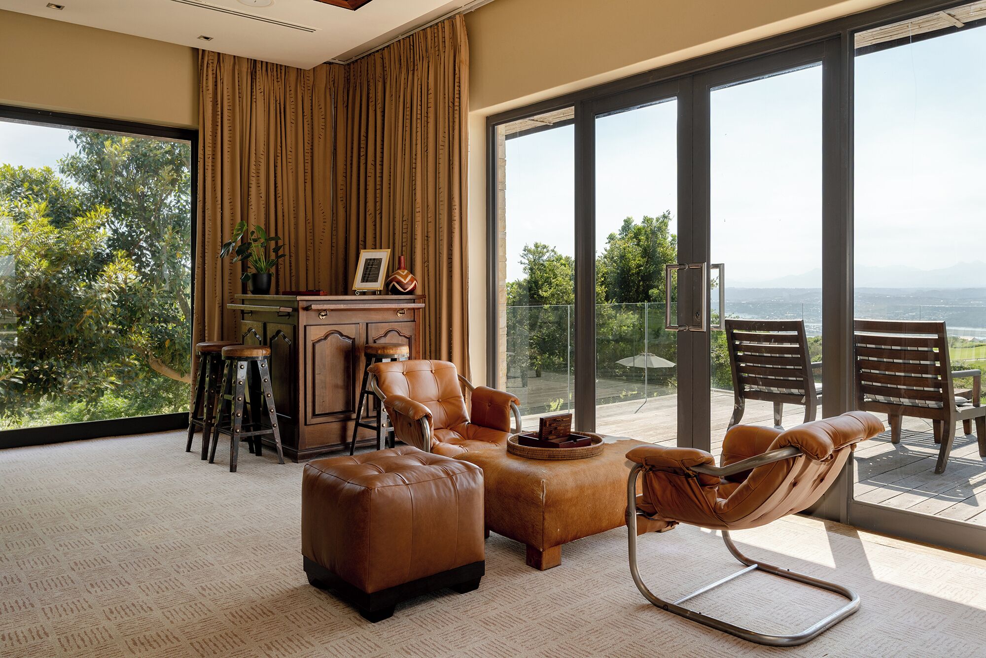 A modern living room with a large sliding glass door leading to a balcony with a view.