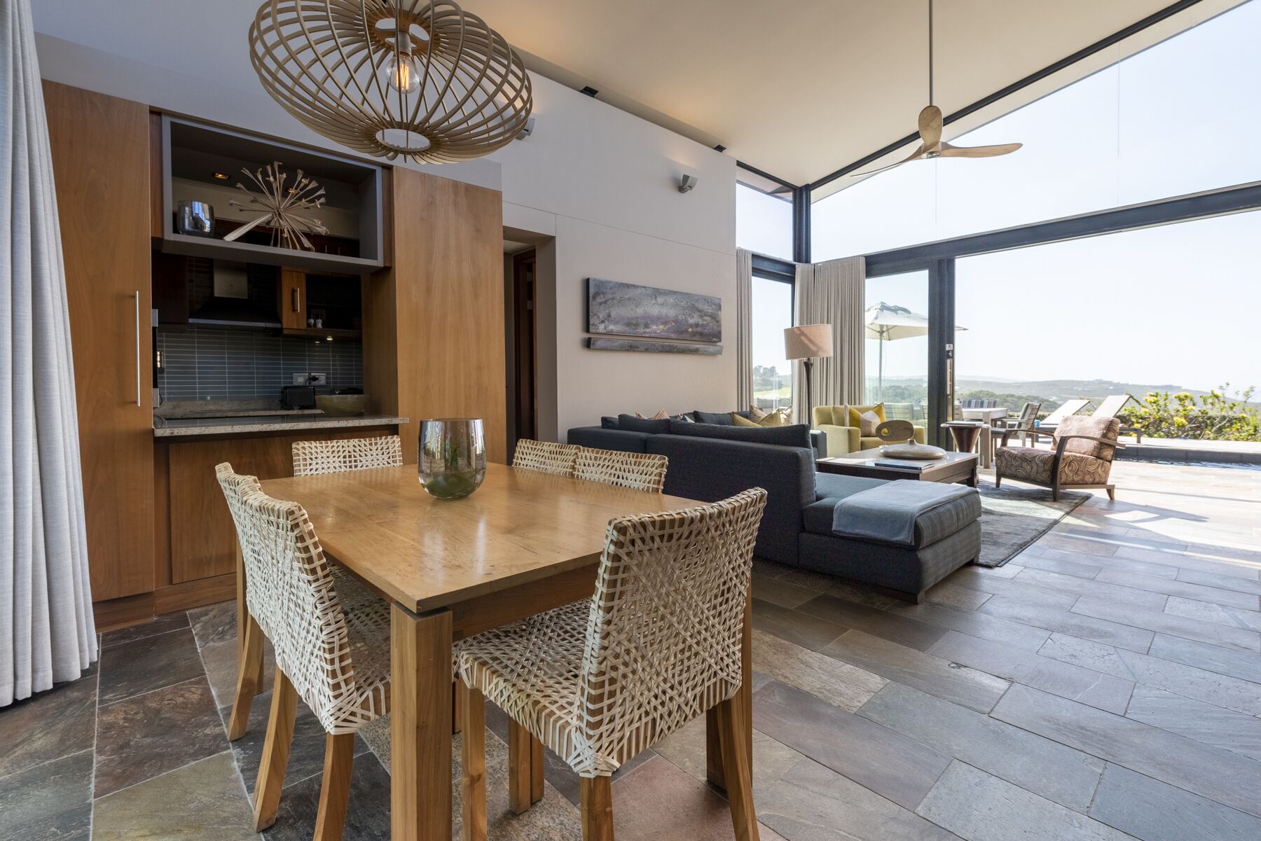 Un interior moderno con comedor, cocina y sala de estar con vistas.
