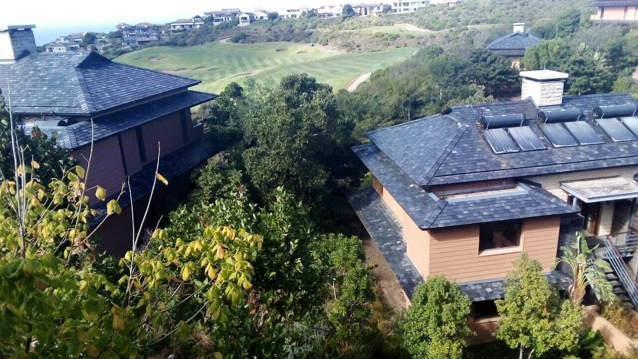A residential area with houses featuring sloped roofs and solar panels.