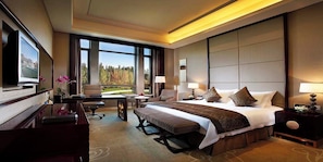 Une chambre d’hôtel avec un grand lit, un bureau, une chaise, une télévision et une vue sur l’extérieur.