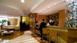 A bar area with a counter, seating, and a display of liquor bottles. - Holiday Inn Cagliari by IHG (Cagliari)
