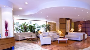 A spacious lobby with multiple seating areas, a reception desk, and a bar. - Holiday Inn Cagliari by IHG (Cagliari)