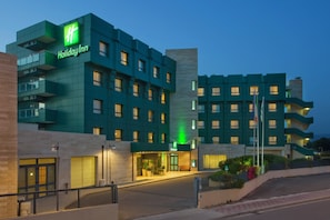 A Holiday Inn hotel with a modern design, featuring multiple floors and balconies.