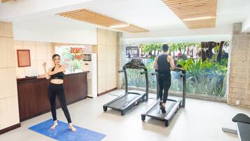 Zona de gimnasio con cintas de correr y una colchoneta azul.