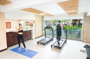 Zona de gimnasio con cintas de correr y una colchoneta azul.