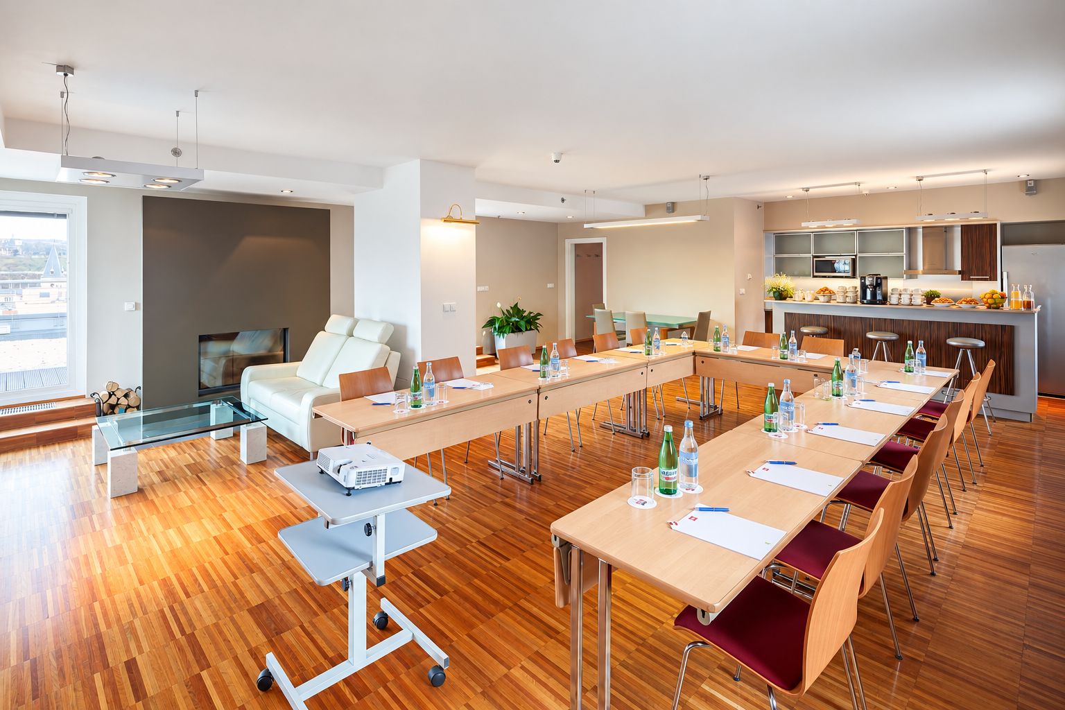 A modern conference room with a long table, chairs, a projector, and a sofa.
