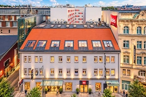 A hotel with a red-tiled roof, multiple windows, and a glass facade. - ibis Praha Old Town (Prague)
