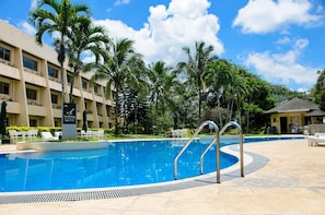 A swimming pool with no diving sign, surrounded by palm trees and a hotel building. - Taal Vista Hotel (Tagaytay)