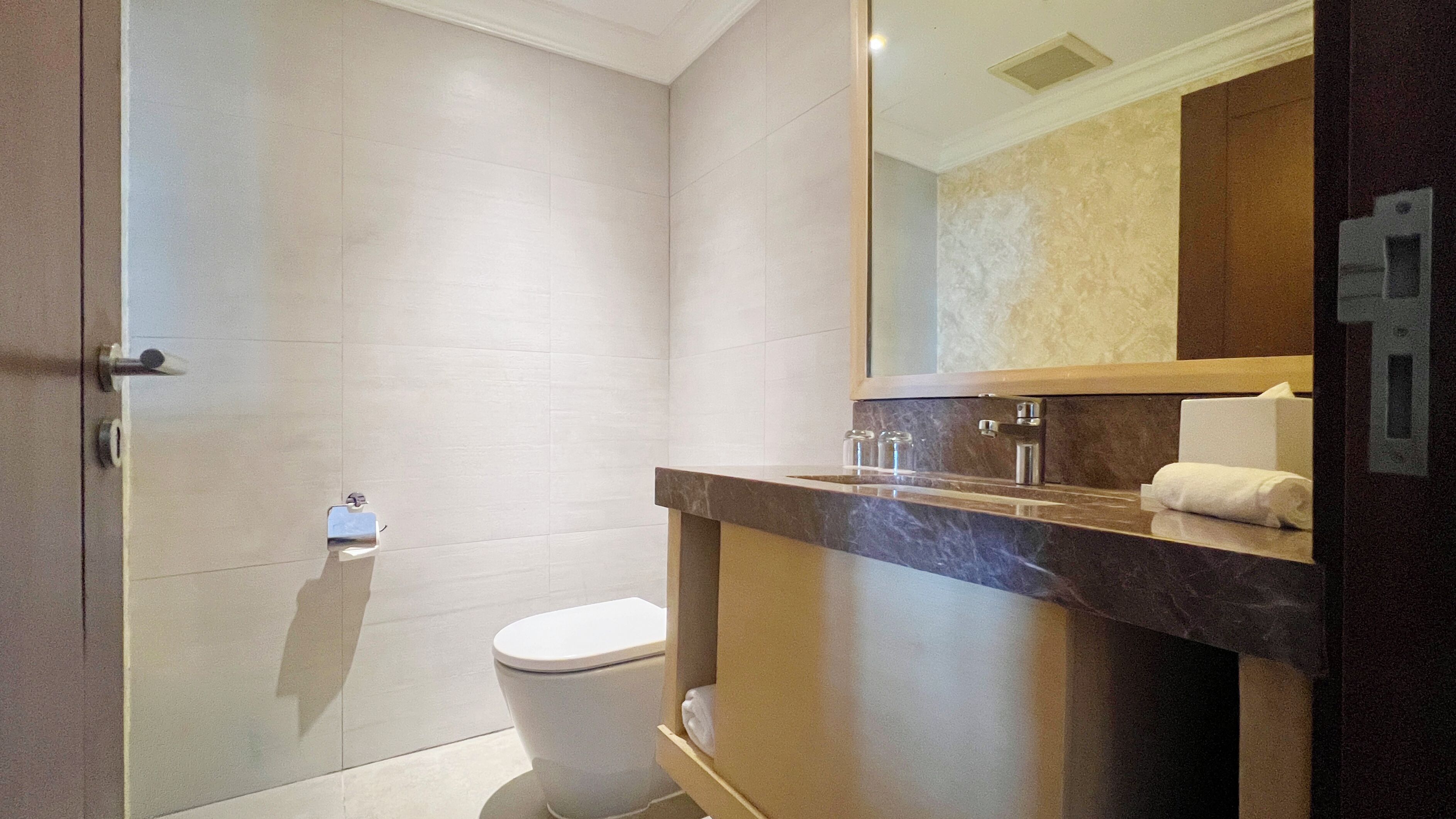 Un baño moderno con inodoro, ducha y tocador con espejo.