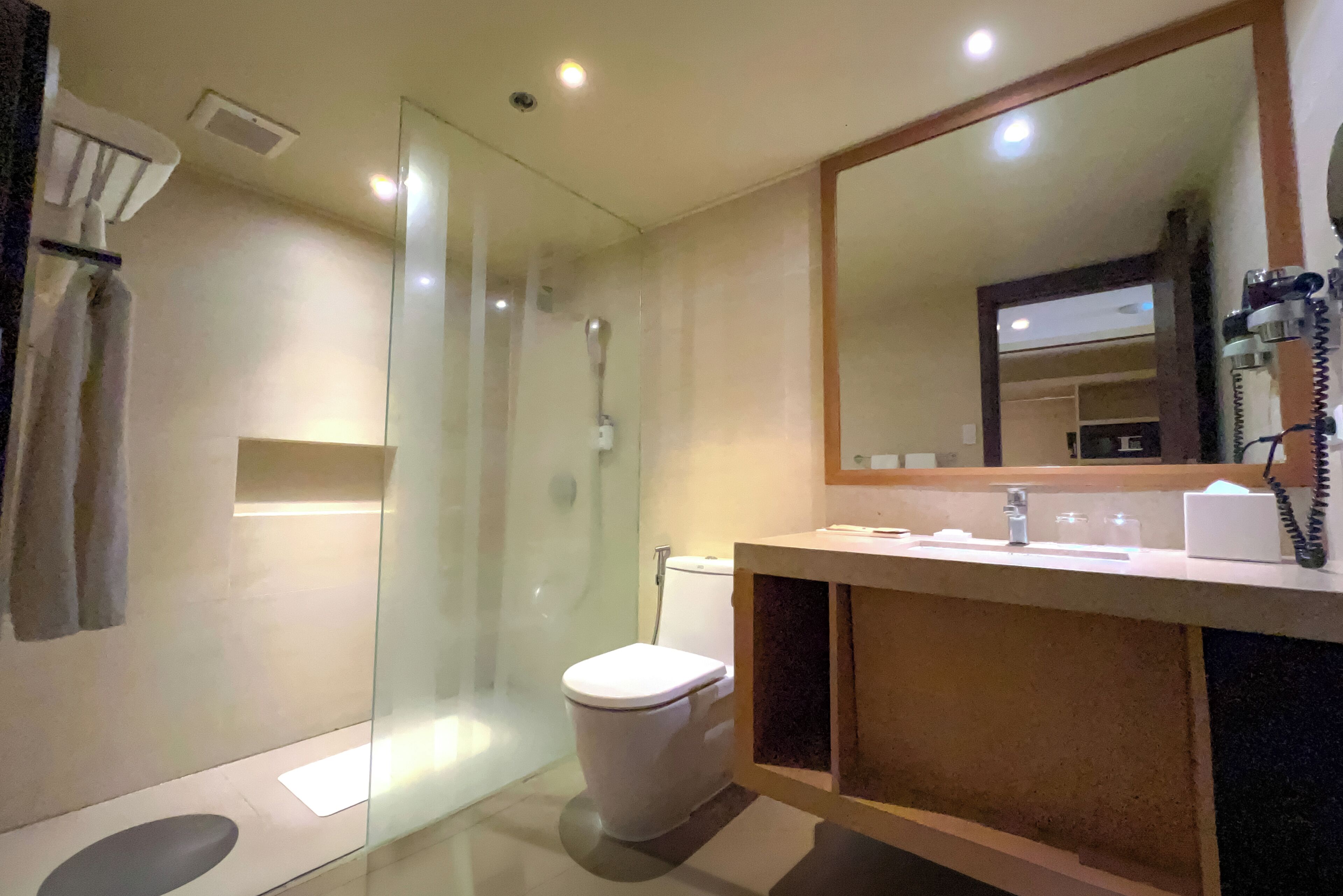 Un baño moderno con ducha envuelta en vidrio, inodoro y tocador con espejo.