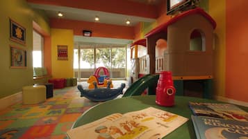 Children can play and learn in this vibrant play area, featuring a colorful play structure, a playhouse, and educational materials.