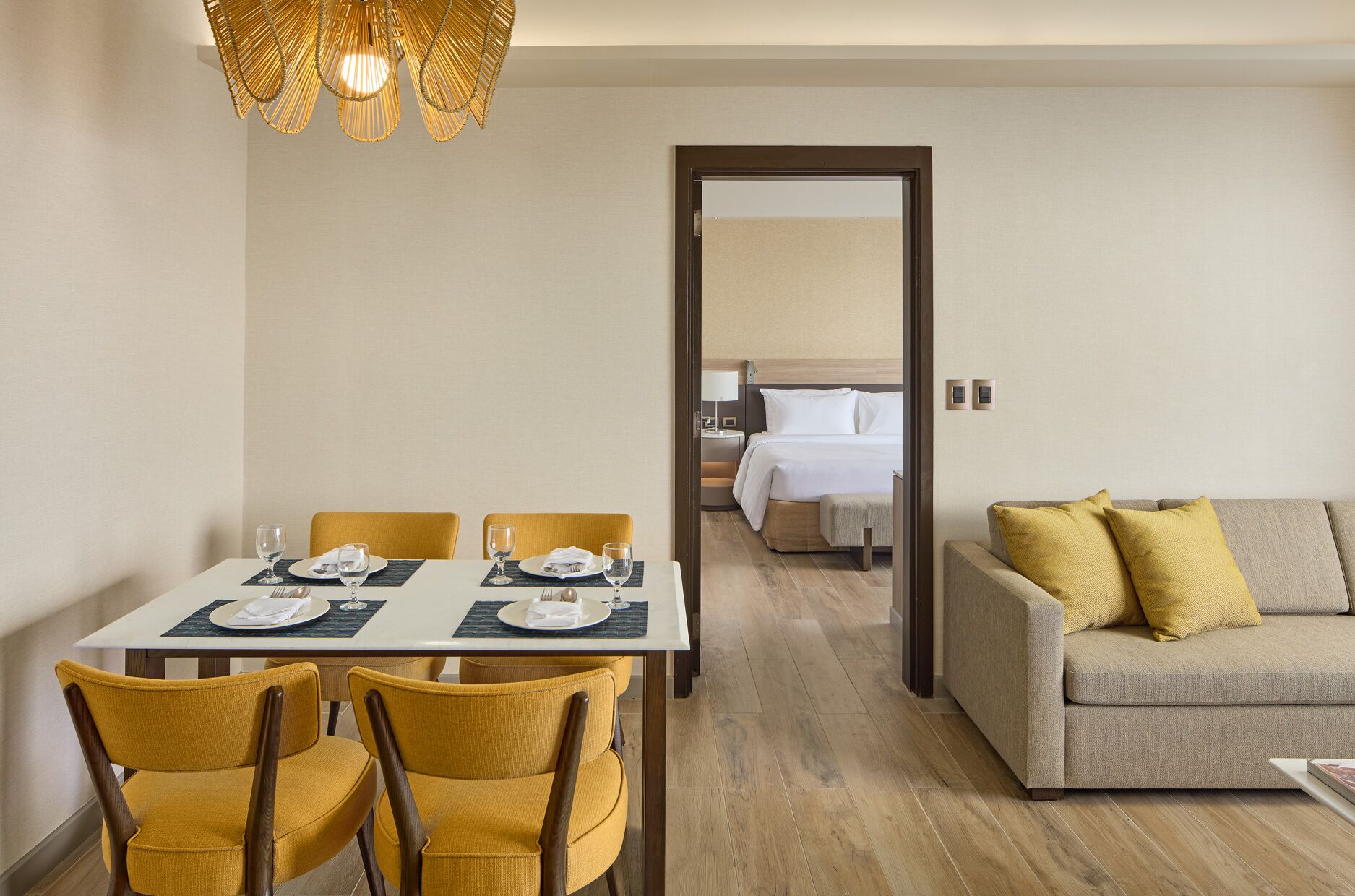 A hotel room with a dining area, a bed, and a sofa.
