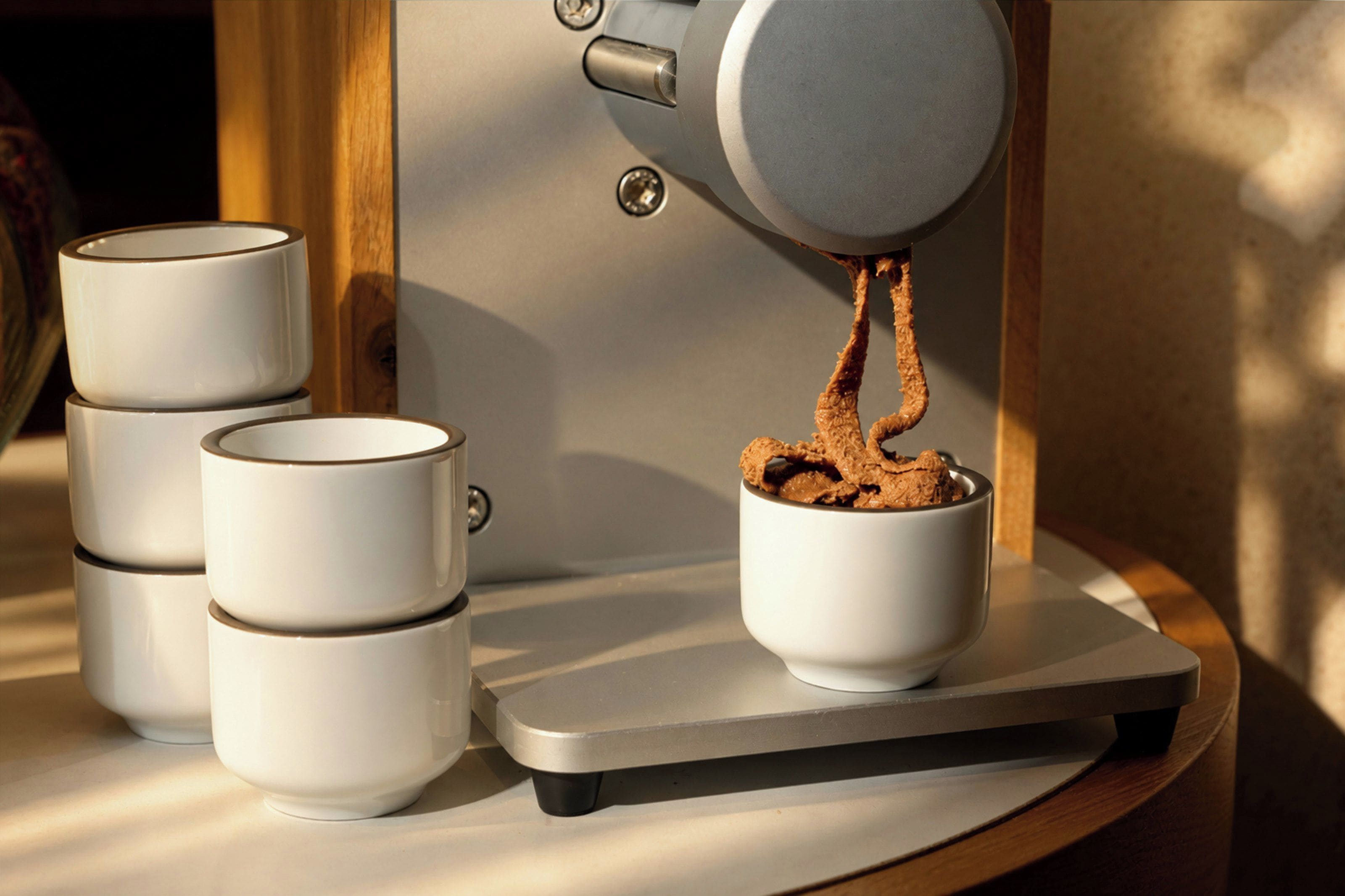 A coffee machine dispensing coffee into a cup on a scale.