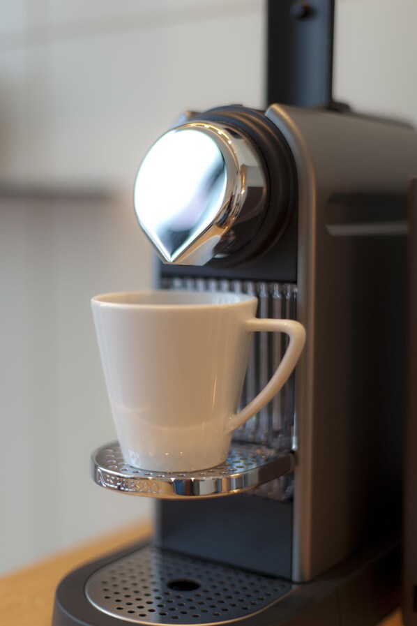 A coffee machine with a cup placed on its drip tray.