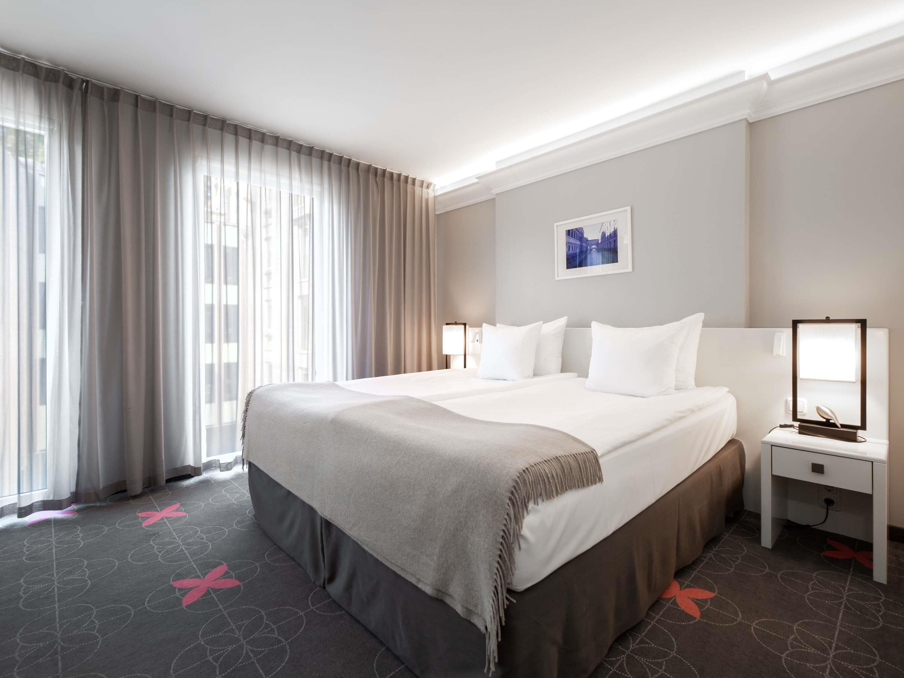 Ropa de cama hipoalergénica y caja de seguridad en la habitación 