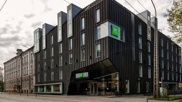 Um edifício moderno com um grande letreiro 'ibis Styles', janelas amplas e entrada coberta.