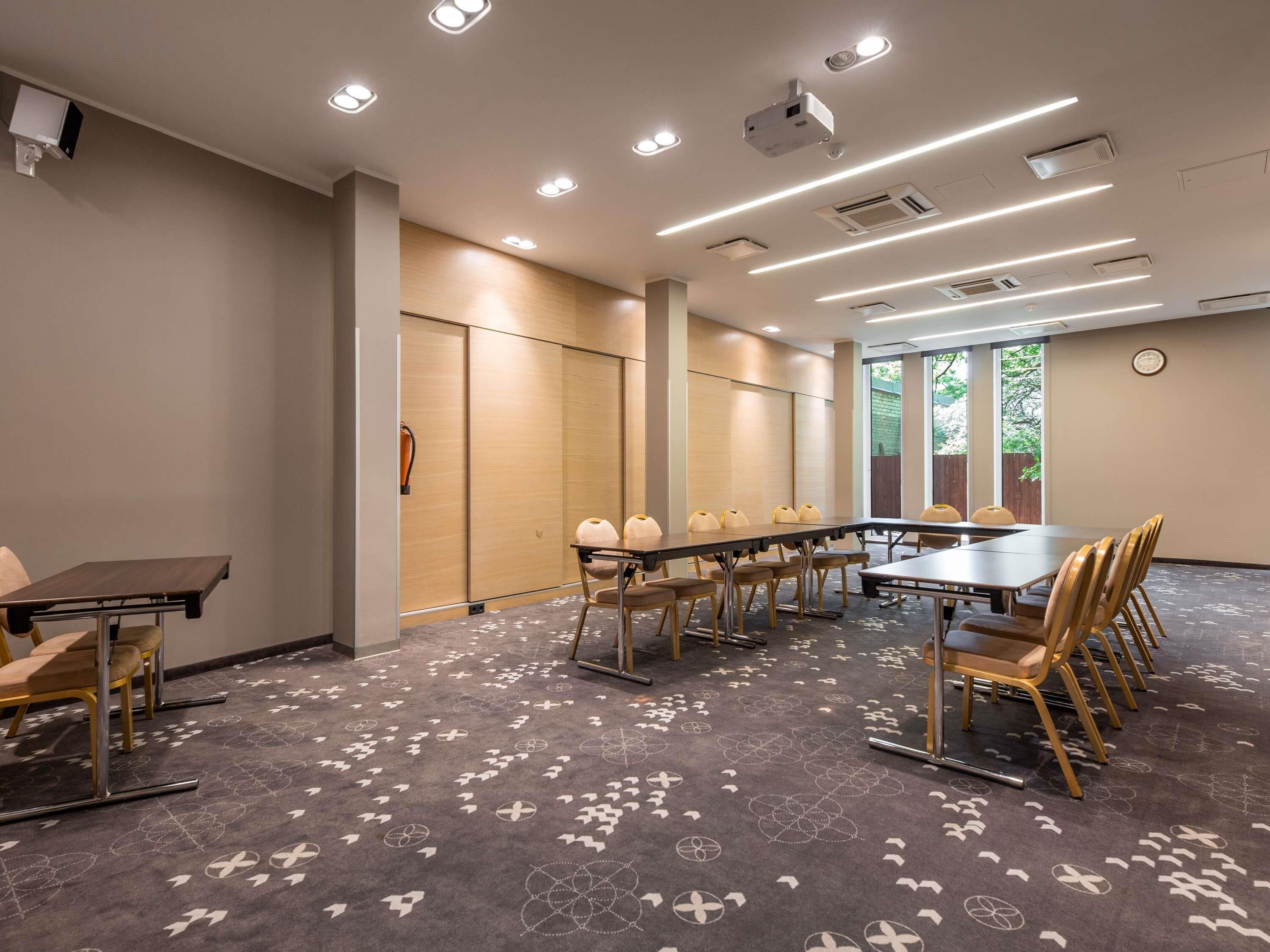 Une salle de conférence avec une longue table, des chaises et un sol recouvert de moquette.