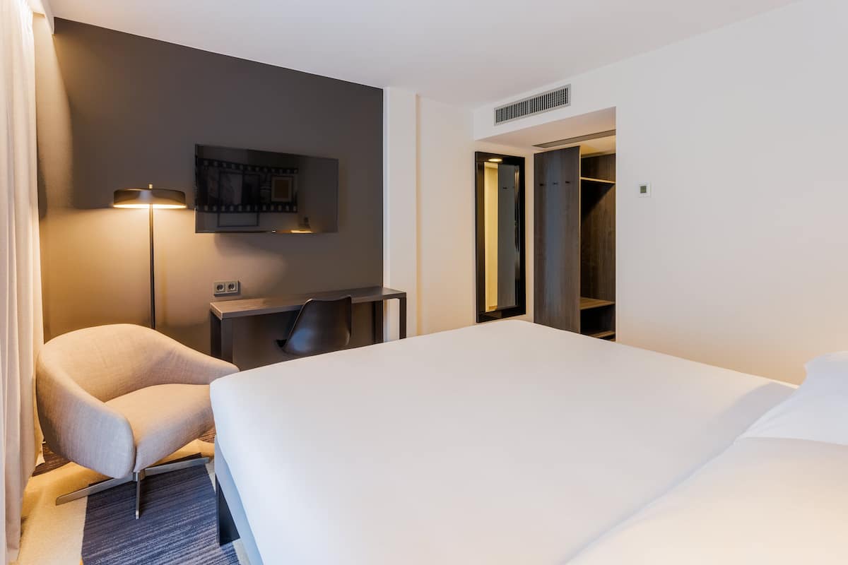 Ropa de cama hipoalergénica y caja de seguridad en la habitación