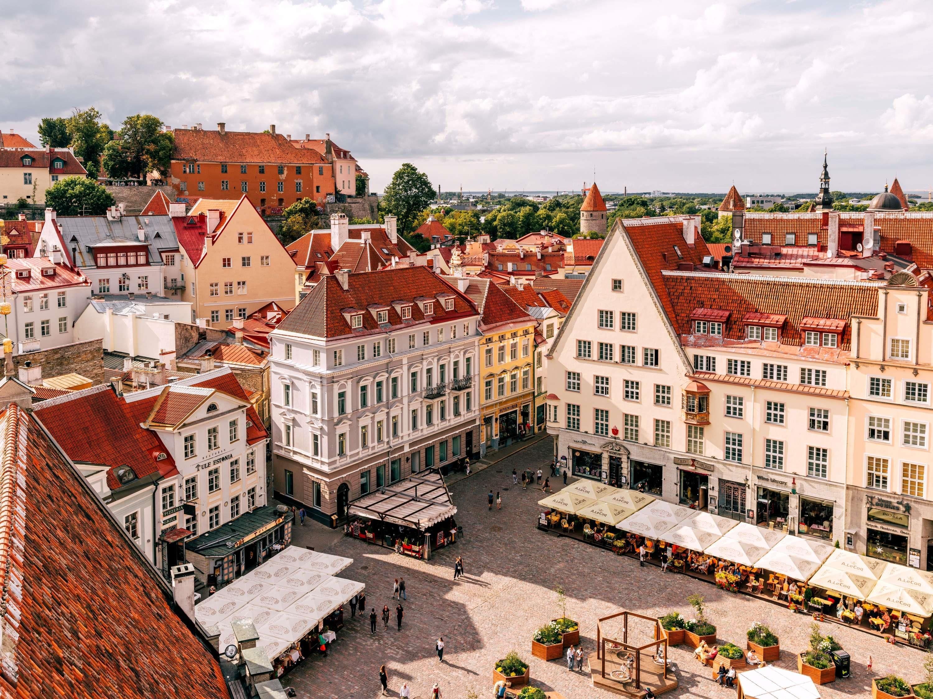 A historic town square with traditional architecture, cobblestone streets, and outdoor seating areas.