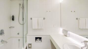 Une salle de bain moderne équipée d’une baignoire, d’une douche, de toilettes et d’un lavabo.