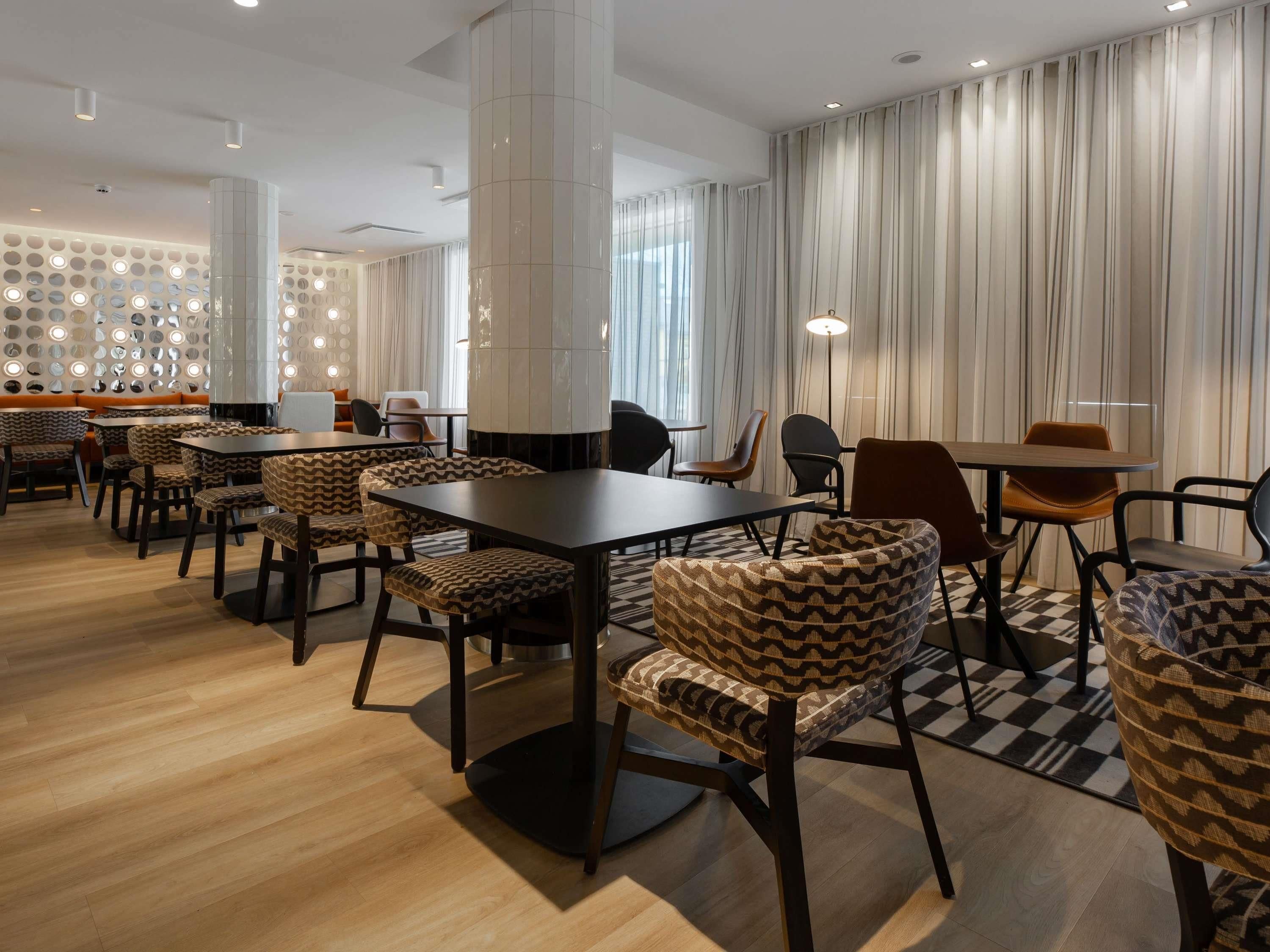 Une chambre d’hôtel moderne, dotée d’un grand lit, d’une table de chevet, d’un bureau et d’une chaise.