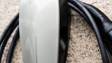 A Tesla charging station with a sign indicating it is for Tesla vehicles.