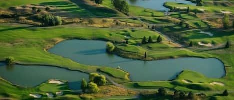 A golf course with multiple ponds and sand bunkers.
