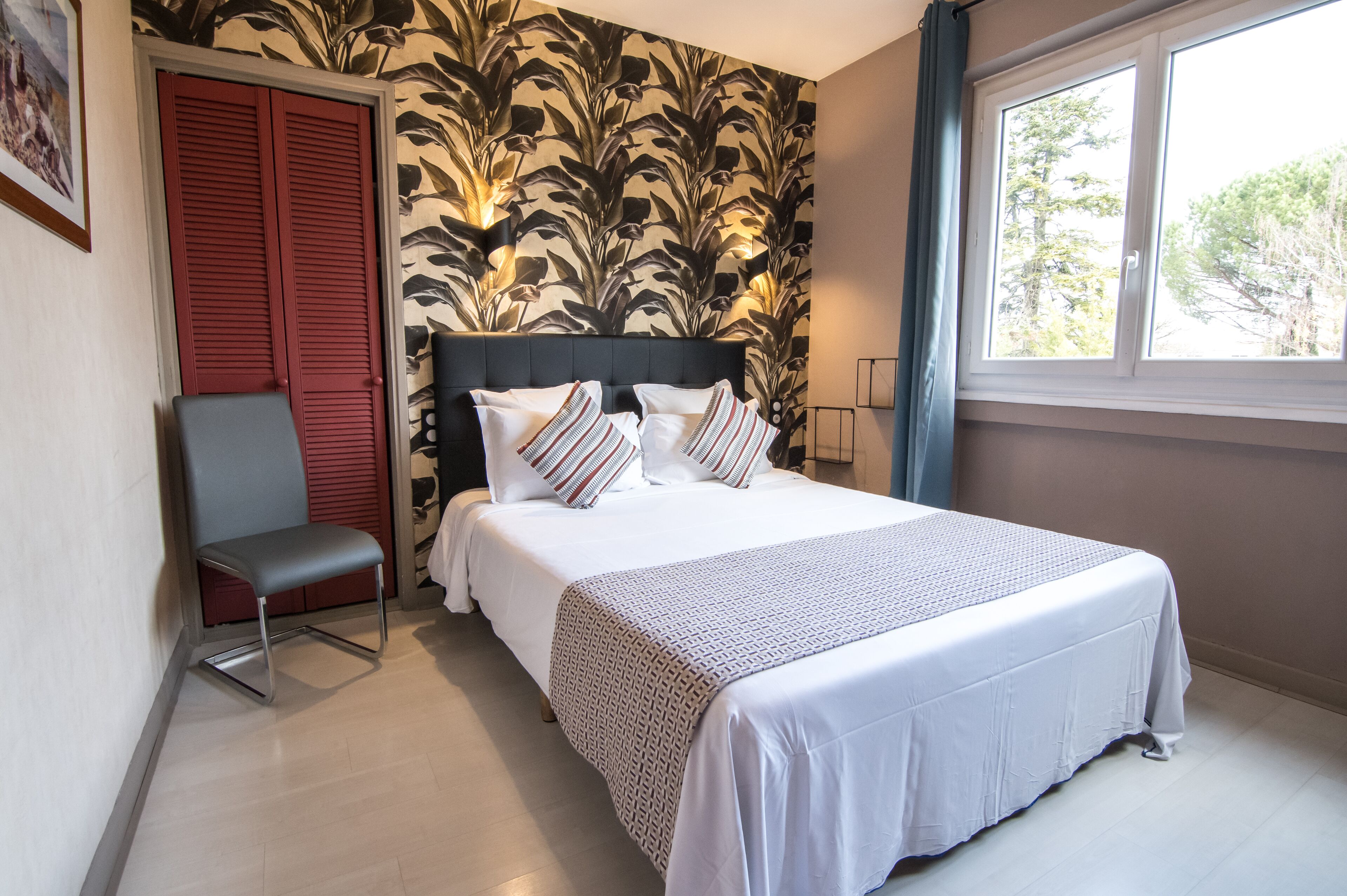 Une chambre à coucher avec un lit, une chaise, une fenêtre et une porte.
